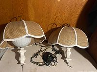 Two matching wicker dome pendant lights on table