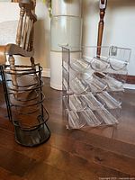 clear plastic stackable bottle organizers next to black metal rack