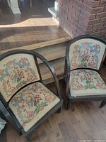 Two vintage embroidered club chairs on hardwood floor
