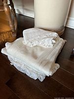 stack of folded lace curtains and valence pieces