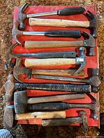 All 13 hammers laid out on red surface
