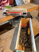 Cardboard box containing loose bits, red round holder and yellow handle