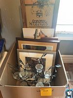 Box showing plaques, framed art and metal votive holder