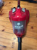 Top view of Dirt Devil Featherlite Cyclonic canister vacuum showing logo and dust bin