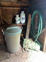 Entire lot inside shed: hose, sprayers, garbage can, stakes, tarp, cord