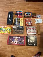 All items laid out showing board games, puzzles, cribbage boards, dice bag, bingo marker tin, dictionaries