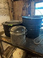 All five enamel canners and three lids on workbench