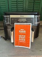 Ninja Foodi DZ090C air fryer front view with quick start guide