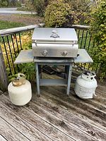 Pit Boss grill on stand with two propane tanks