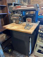 Full view of Craftsman table saw with cabinet base and miter gauge on wooden top