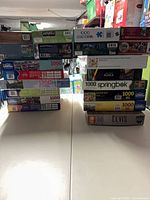 Two vertical stacks of boxed puzzles on a table