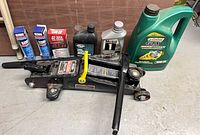 Overall lot showing trolley jack and assortment of automotive fluids