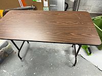 Top view of rectangular folding table showing wood-grain laminate surface