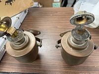 Top view showing open burner caps, wick and mesh of both lamps