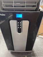 Front view of Haier portable air conditioner displaying 64°F
