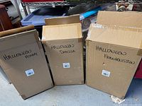 Three labeled shipping boxes for each statue