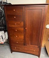 Front view of cherry door chest showing drawers and door