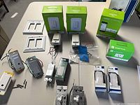 All items laid out on table: boxed Wemo products, loose dimmers and switches, cover plates, screws