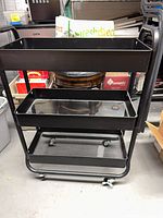 Front view showing three mesh shelves and casters