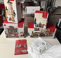 All six boxed village items displayed on table