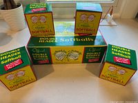 Five individual DeBeer Double Header softball boxes and one larger DeBeer box showing product branding