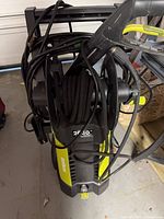 Front view showing Sun Joe pressure washer, 2030 PSI marking, hose reel and cords