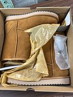 Side view of chestnut suede ankle boots in original box with tissue