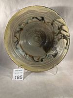 Front view of glazed stoneware bowl on stand