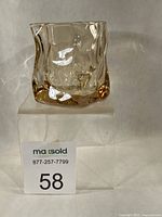 Front view of Colabrili twisted glass on acrylic riser