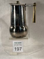 Full view of espresso maker on stand showing polished body and brass handle