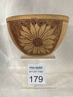 Stoneware bowl front view showing sunflower relief and overall form