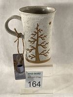 Full mug with tag displayed on stand