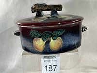 Side view showing exterior glaze, fruit motif and side handle