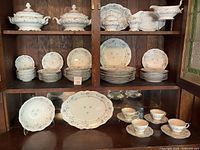 Cabinet view showing majority of set including plates, serving dishes, cups, saucers