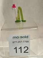 Miniature glass inchworm on clear riser with lot tag