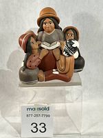 Front view of Peruvian storyteller figurine showing mother with book and four children