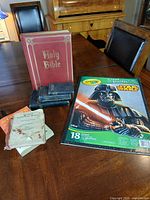 All books arranged on table including Holy Bible, pocket Bibles, RCMP manual, two booklets and Crayola Star Wars coloring book