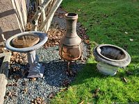 Birdbath, chiminea and planter grouped outdoors