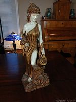 Front view of Grecian female statue on table