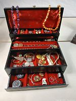 Overall view of open jewellery box showing contents across three tiers
