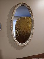 Front view of oval mirror hanging on wall