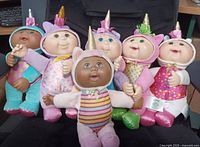 Group shot of all six CPK Cuties Unicorn dolls seated together