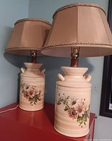 Two matching ceramic milk can lamps with shades side view