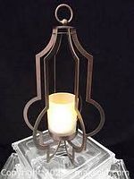 Metal Marrakech style votive holder with candle inside, front view