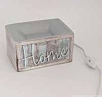 Front view showing rustic wood texture and raised "Home" script