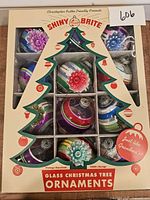 Front view of unopened box showing 12 ornaments through tree-shaped window