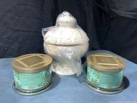 Overview of two Snow Tipped Pine candles and white ceramic lidded vessel
