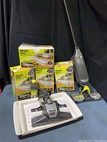 Overview of Vacmop stick, four pad boxes, cleaner bottle, Genie head in tray