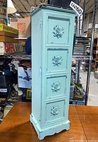 Full front view of painted cabinet showing floral panels