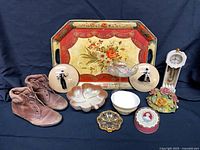 Group shot all items showing tray, boots, dishes, plates, glassware, clock, bouquet, tin